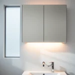 Explore a stylish bathroom cabinet with mirror and light in a bright, elegant bathroom setting.
