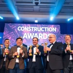 Celebrate achievements at Construction awards event showcasing proud winners with trophies.